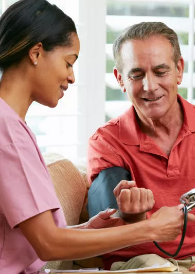 home health aid measuring a man's blood pressure