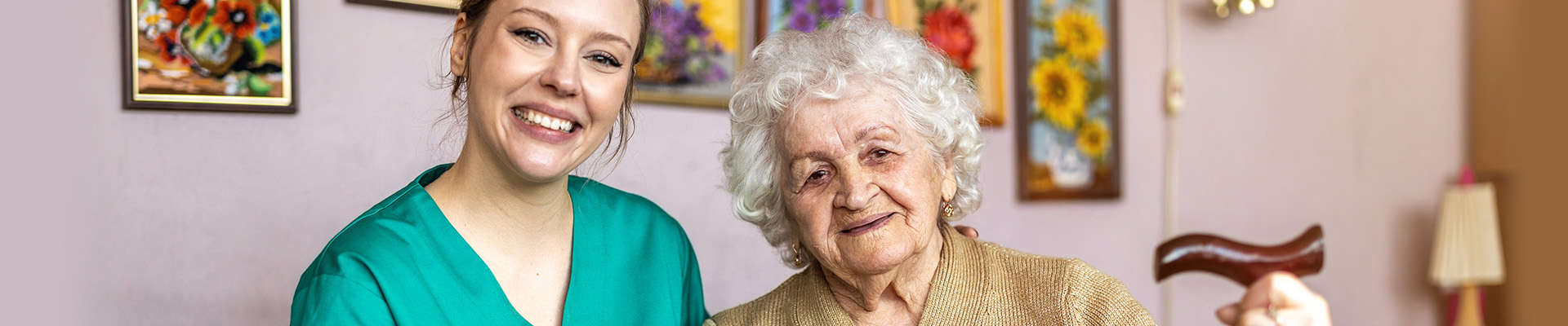 female nurse sitting with senior patient on her couch at home